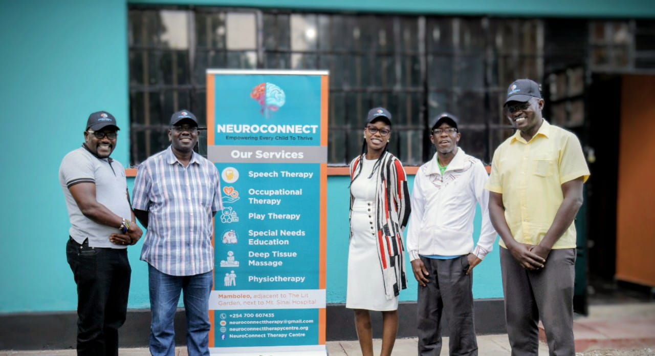 NeuroConnect Therapy Centre directors and staff team standing with services banner